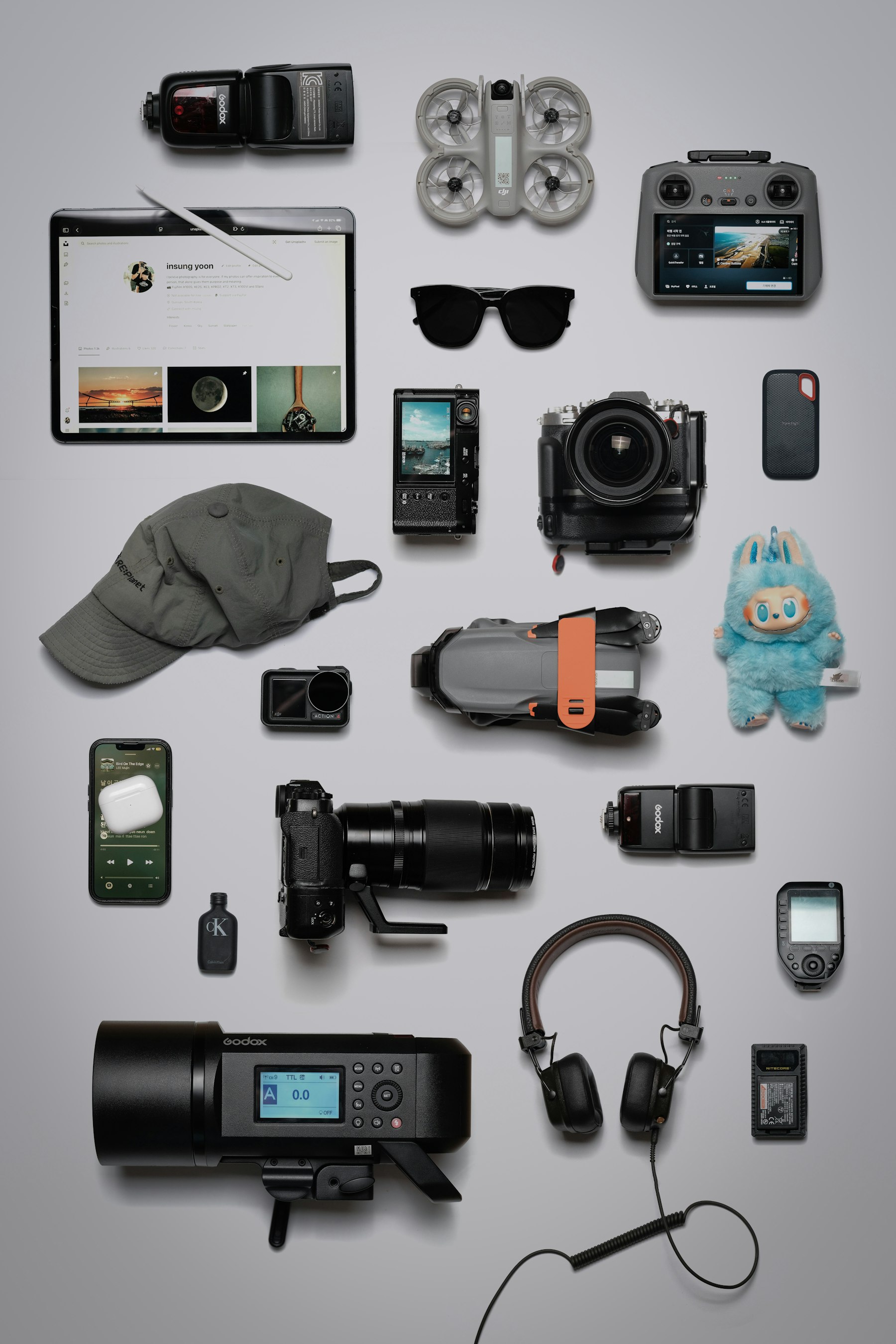 Prodotti tecnologici disposti con ordine: fotocamera, cuffie, accessori e dispositivi